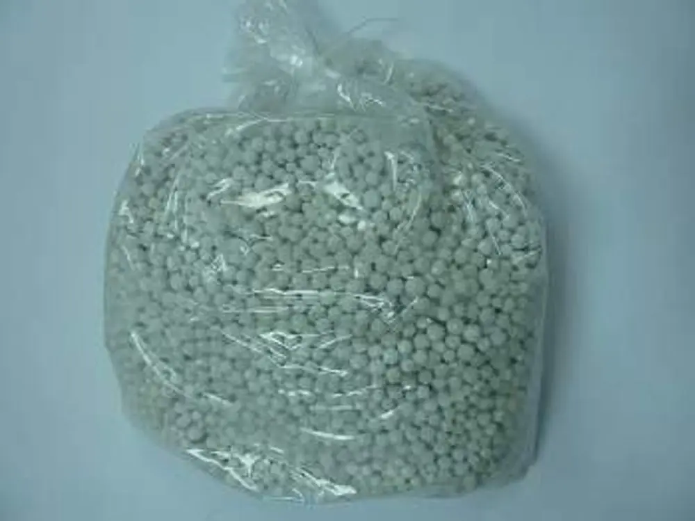Plastiktüte mit kleinen, runden Granulatkugeln, offenbar von der Marke Remeha, auf hellem Hintergrund. Die Kugeln sind hell und gleichmäßig verteilt.
